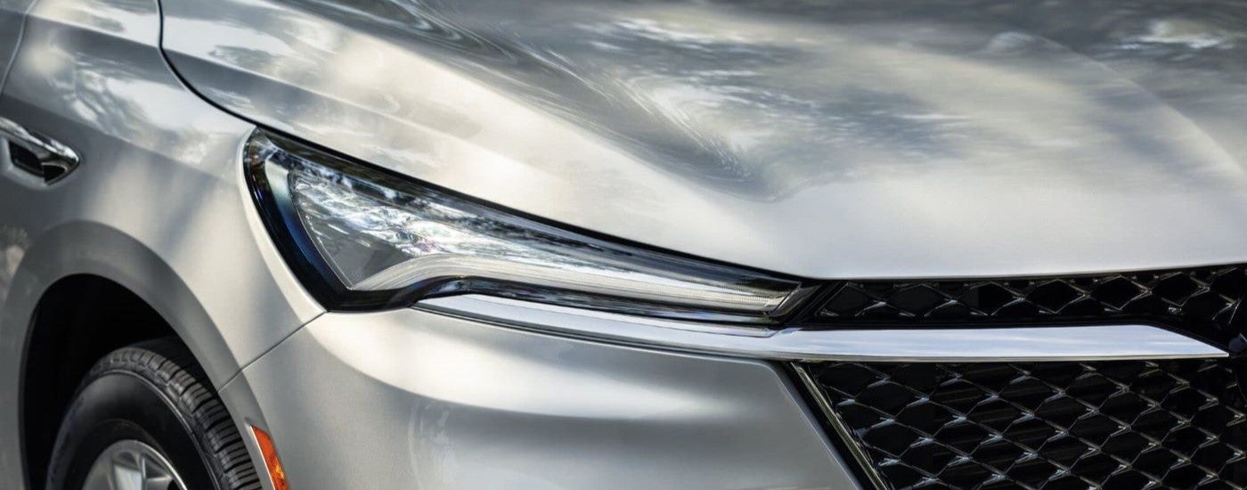 A close-up of the headlight on a silver 2023 Buick Enclave Avenir is shown.